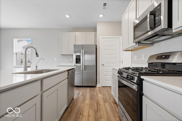 11431 Hartwell St, Indianapolis, IN 46235 - kitchen featuring stainless steel appliances, light wood-type flooring, light countertops, white cabinetry, and recessed lighting