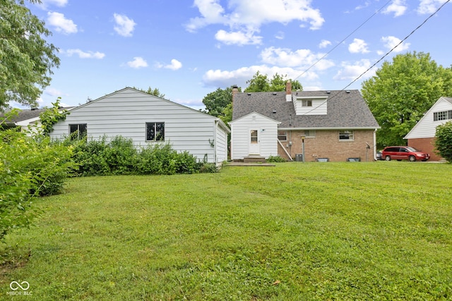 2752 Vinewood Dr, Speedway, IN 46224 - rear view of property with a yard, a chimney, and brick siding