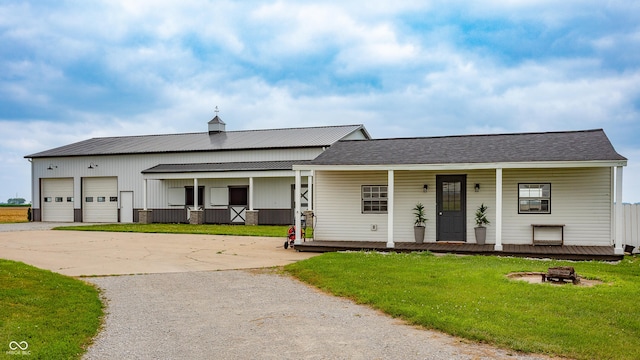 4729 W 100 N, Wolcott, IN 47995 - view of front of home with a porch, a fire pit, a front yard, an attached garage, and driveway