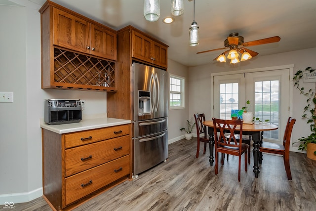4729 W 100 N, Wolcott, IN 47995 - kitchen featuring stainless steel refrigerator with ice dispenser, brown cabinetry, ceiling fan, light wood-type flooring, and light countertops