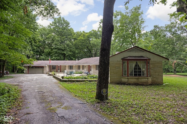 5519 N County Rd 550 E, Pittsboro, IN 46167 - ranch-style home with an attached garage, driveway, concrete block siding, and a front lawn