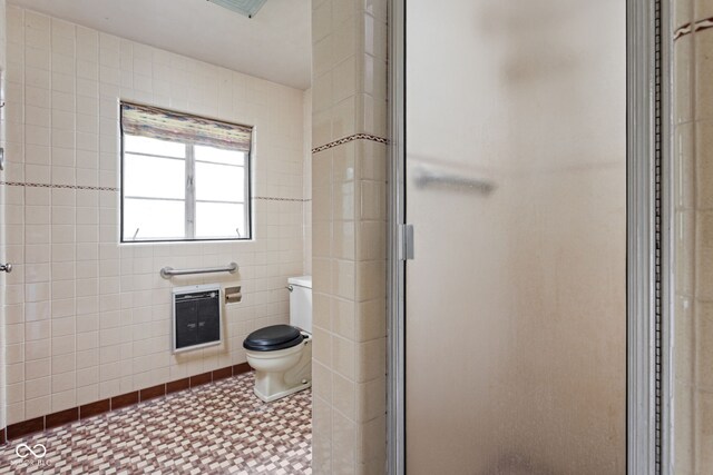 5519 N County Rd 550 E, Pittsboro, IN 46167 - bathroom with heating unit, a stall shower, tile patterned floors, and tile walls