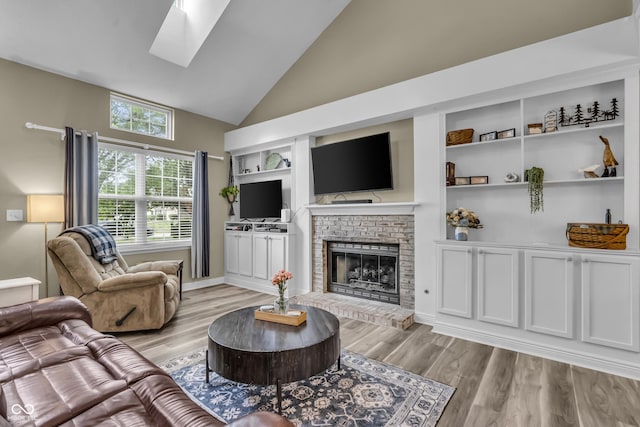 10832 Washington Bay Dr, Fishers, IN 46037 - living area featuring high vaulted ceiling, a brick fireplace, a skylight, and light wood finished floors