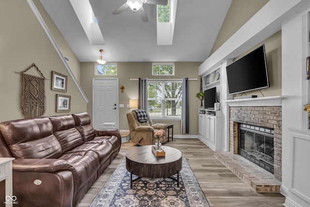 10832 Washington Bay Dr, Fishers, IN 46037 - living area with ceiling fan, light wood-type flooring, a skylight, a brick fireplace, and high vaulted ceiling