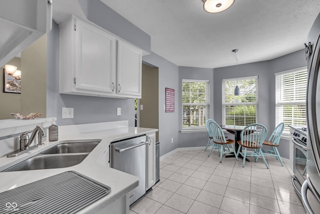10832 Washington Bay Dr, Fishers, IN 46037 - kitchen featuring stainless steel appliances, light countertops, white cabinets, decorative light fixtures, and light tile patterned flooring