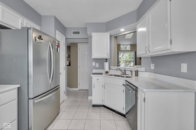 10832 Washington Bay Dr, Fishers, IN 46037 - kitchen featuring stainless steel appliances, white cabinets, light countertops, light tile patterned floors, and a textured ceiling