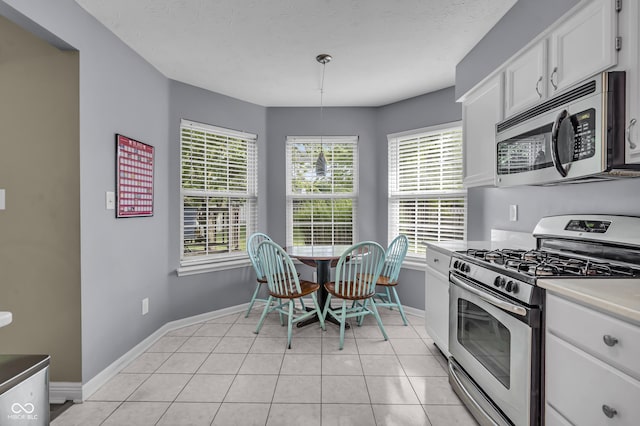10832 Washington Bay Dr, Fishers, IN 46037 - kitchen featuring appliances with stainless steel finishes, white cabinetry, light tile patterned floors, pendant lighting, and light countertops