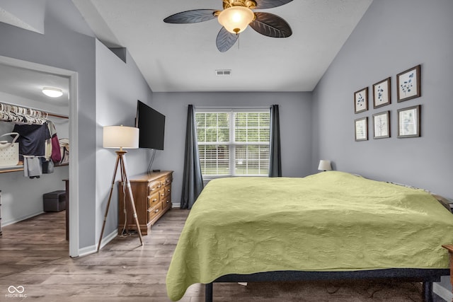 10832 Washington Bay Dr, Fishers, IN 46037 - bedroom with lofted ceiling, wood finished floors, a walk in closet, and ceiling fan