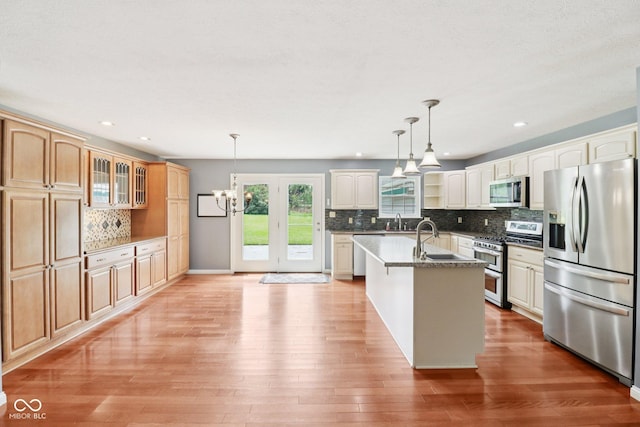 151 S St, Southport, IN 46227 - kitchen featuring stainless steel appliances, tasteful backsplash, glass insert cabinets, light wood finished floors, and a chandelier