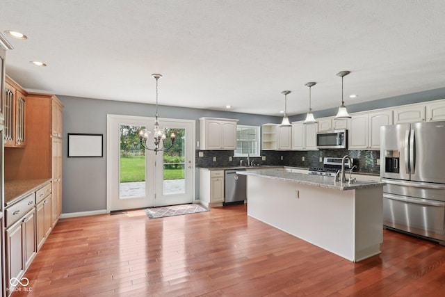 151 S St, Southport, IN 46227 - kitchen featuring stainless steel appliances, decorative backsplash, light wood finished floors, light stone countertops, and recessed lighting