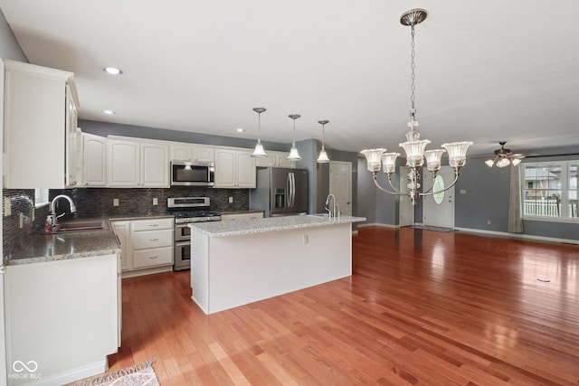 151 S St, Southport, IN 46227 - kitchen with stainless steel appliances, white cabinets, tasteful backsplash, wood finished floors, and recessed lighting