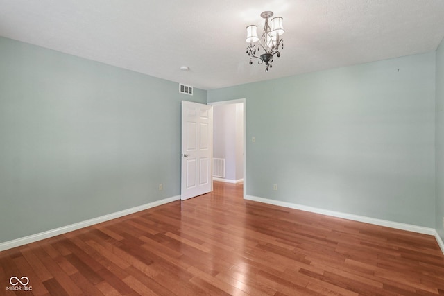 151 S St, Southport, IN 46227 - spare room with wood finished floors and a chandelier