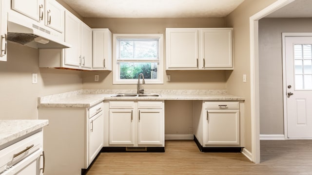 3613 Moller Rd, Indianapolis, IN 46224 - kitchen with under cabinet range hood, light wood-style flooring, white cabinets, and light countertops