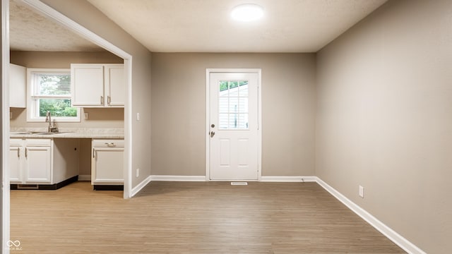 3613 Moller Rd, Indianapolis, IN 46224 - kitchen featuring light wood-type flooring, white cabinetry, and light countertops