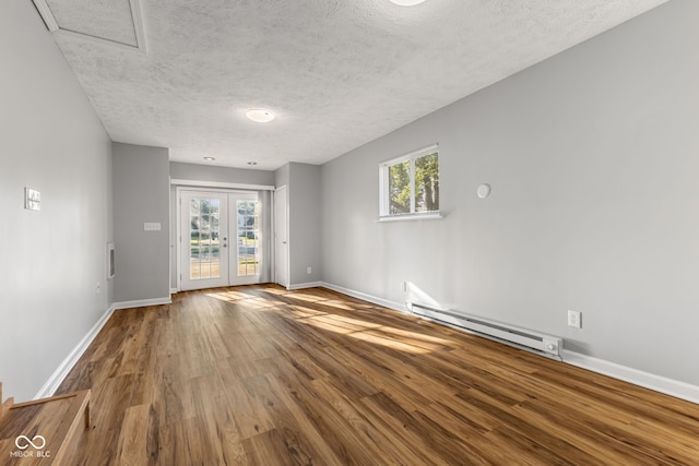 748 Maple Ln, Brownsburg, IN 46112 - spare room featuring baseboard heating, wood finished floors, a textured ceiling, and french doors