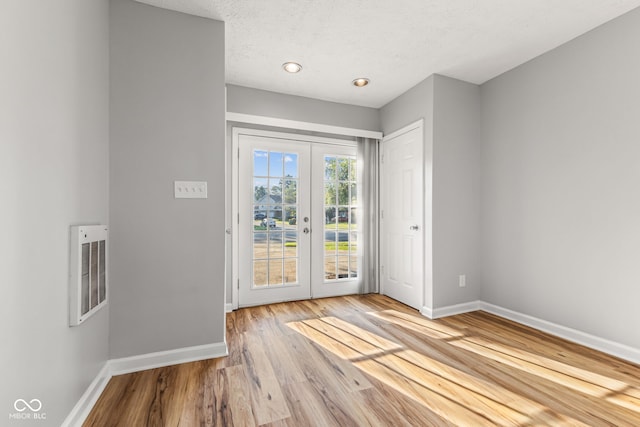 748 Maple Ln, Brownsburg, IN 46112 - entrance foyer featuring french doors, wood finished floors, and a textured ceiling