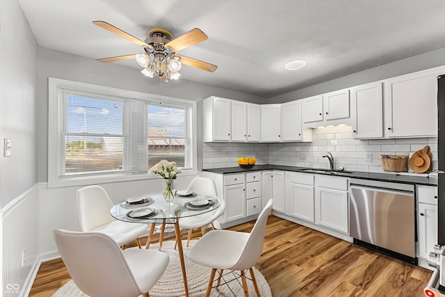 748 Maple Ln, Brownsburg, IN 46112 - kitchen with dishwasher, ceiling fan, dark countertops, light wood-style flooring, and wainscoting