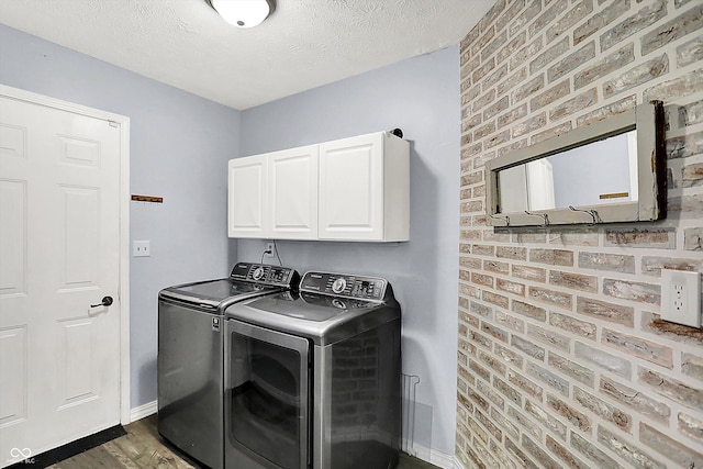 6059 Buck Blvd, Indianapolis, IN 46237 - laundry room with independent washer and dryer, cabinet space, a textured ceiling, brick wall, and dark wood-style floors