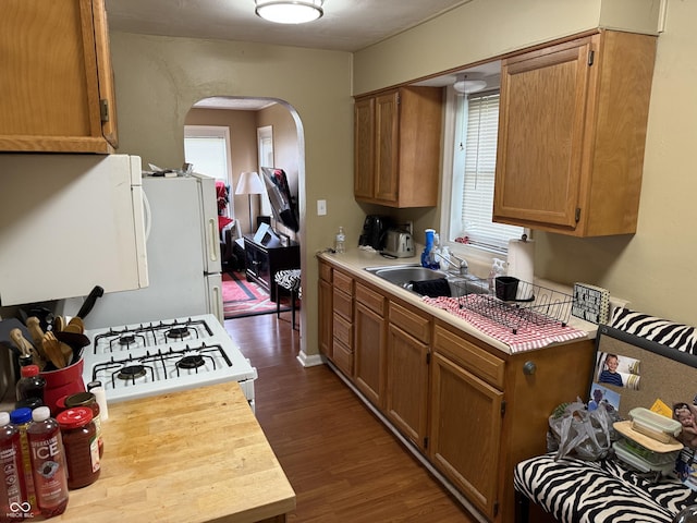 314 E Mill St, Fortville, IN 46040 - kitchen featuring arched walkways, light countertops, dark wood finished floors, and white gas stove