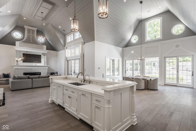 520 Willow Spring Rd, Indianapolis, IN 46240 - kitchen featuring high vaulted ceiling, open floor plan, wood finished floors, white cabinetry, and pendant lighting
