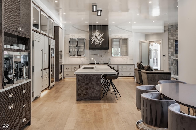 520 Willow Spring Rd, Indianapolis, IN 46240 - kitchen with light wood-style floors, open floor plan, glass insert cabinets, a kitchen breakfast bar, and backsplash