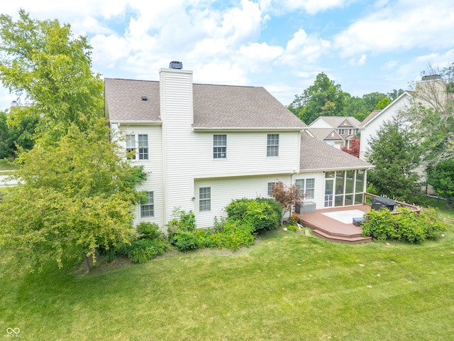 12817 Mojave Dr, Fishers, IN 46037 - back of property featuring a sunroom, a chimney, a deck, a yard, and a shingled roof