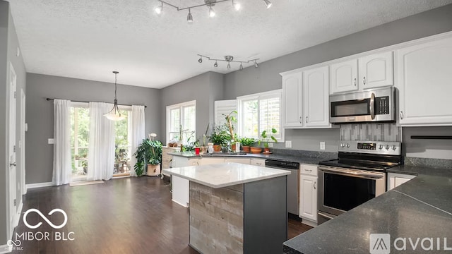 12817 Mojave Dr, Fishers, IN 46037 - kitchen featuring appliances with stainless steel finishes, white cabinetry, dark wood-style flooring, and a textured ceiling