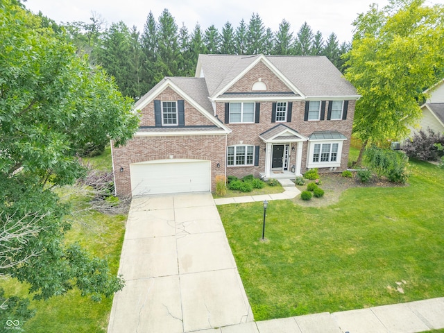 12817 Mojave Dr, Fishers, IN 46037 - colonial house featuring concrete driveway, brick siding, a front yard, and a garage