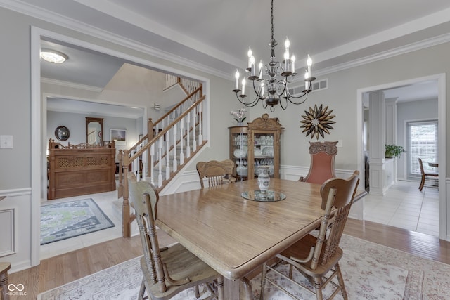 860 Old Eagle Way, Greenwood, IN 46143 - dining room featuring stairway, light wood-style floors, a chandelier, and crown molding
