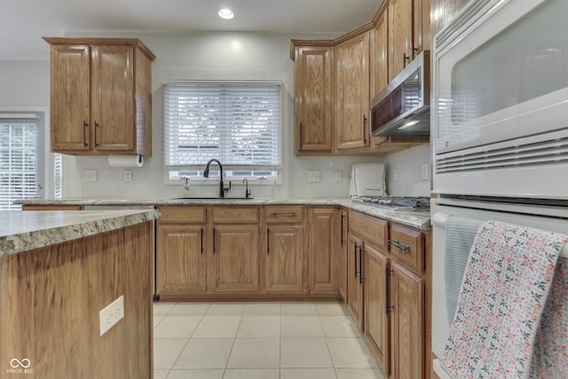 860 Old Eagle Way, Greenwood, IN 46143 - kitchen featuring white appliances, brown cabinets, light stone counters, light tile patterned floors, and recessed lighting