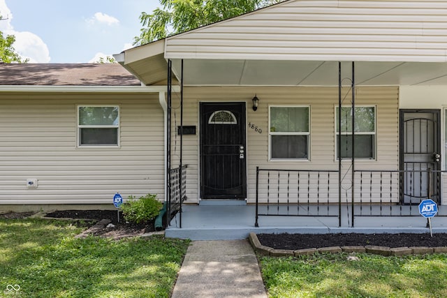 4880 N Katherine Dr, Indianapolis, IN 46226 - doorway to property featuring covered porch, roof with shingles, and a lawn