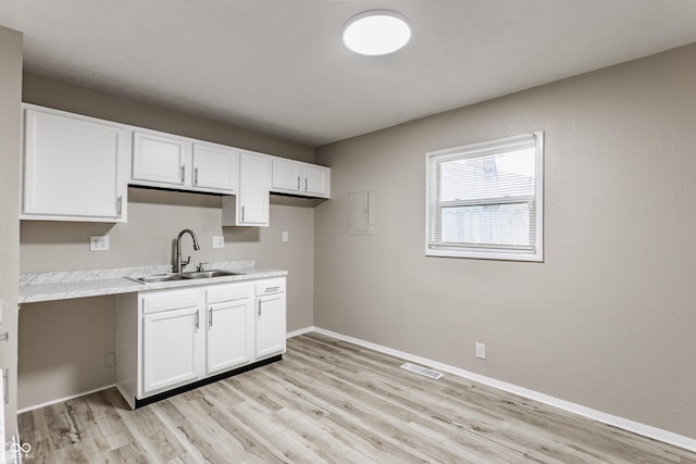 4880 N Katherine Dr, Indianapolis, IN 46226 - kitchen featuring light countertops, light wood-type flooring, white cabinets, and electric panel