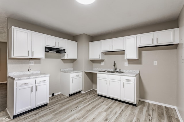 4880 N Katherine Dr, Indianapolis, IN 46226 - kitchen featuring light wood-style floors, white cabinetry, under cabinet range hood, and light countertops