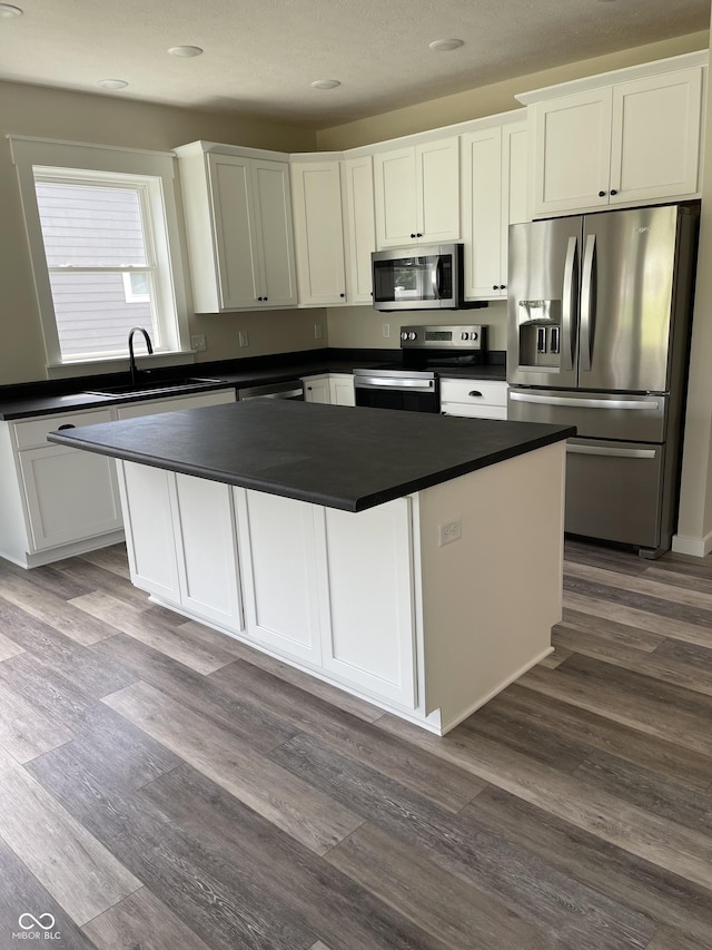 842 E Nutter St, Martinsville, IN 46151 - kitchen featuring appliances with stainless steel finishes, dark countertops, white cabinets, a center island, and dark wood-style floors