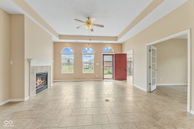 2815 Grandview Ln, Greenwood, IN 46143 - unfurnished living room featuring a ceiling fan, a tile fireplace, a tray ceiling, and light tile patterned floors