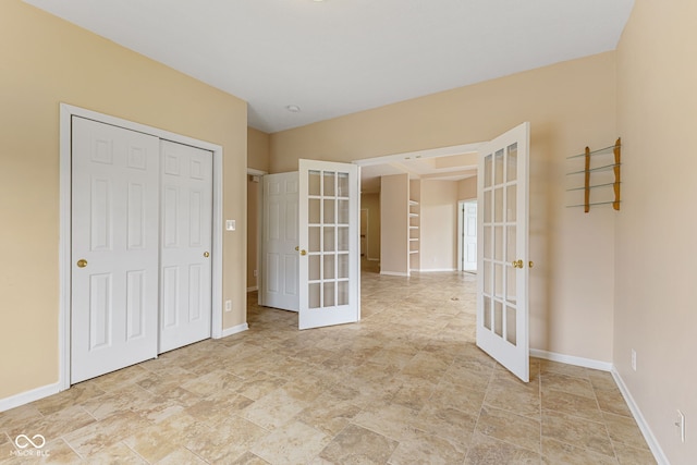 2815 Grandview Ln, Greenwood, IN 46143 - unfurnished bedroom featuring french doors, a closet, and light stone finish flooring