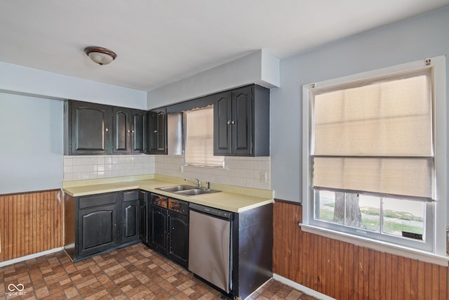 3408 Harvest Ave, Indianapolis, IN 46226 - kitchen with stainless steel dishwasher, wainscoting, light countertops, wooden walls, and backsplash