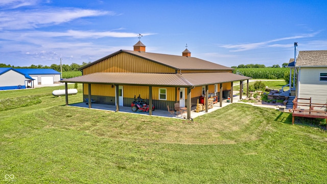 4297 W Division Rd, Crawfordsville, IN 47933 - rear view of property featuring a patio area, a yard, a metal roof, and board and batten siding