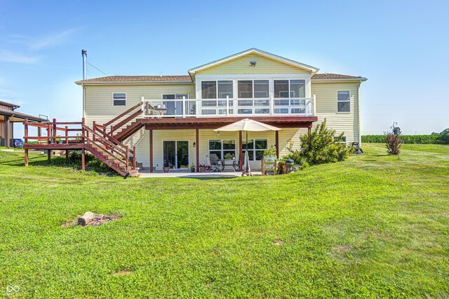 4297 W Division Rd, Crawfordsville, IN 47933 - rear view of house featuring stairs, a sunroom, a wooden deck, a patio area, and a lawn