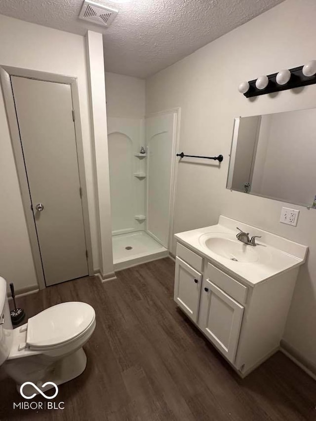 95 Rural St, Austin, IN 47102 - bathroom featuring wood finished floors, a shower stall, vanity, and a textured ceiling
