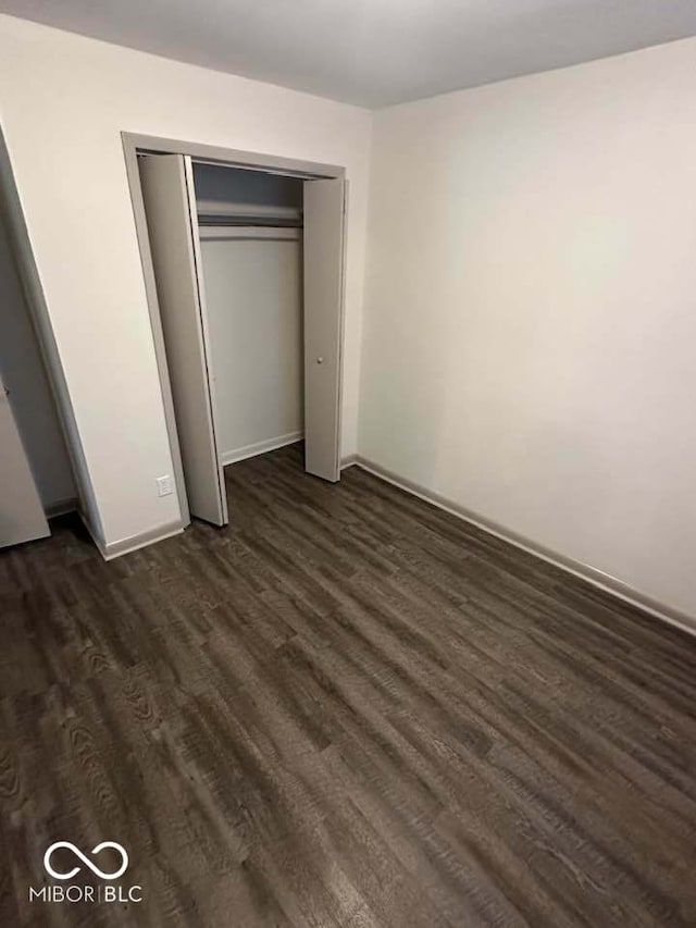 95 Rural St, Austin, IN 47102 - unfurnished bedroom with dark wood finished floors and a closet