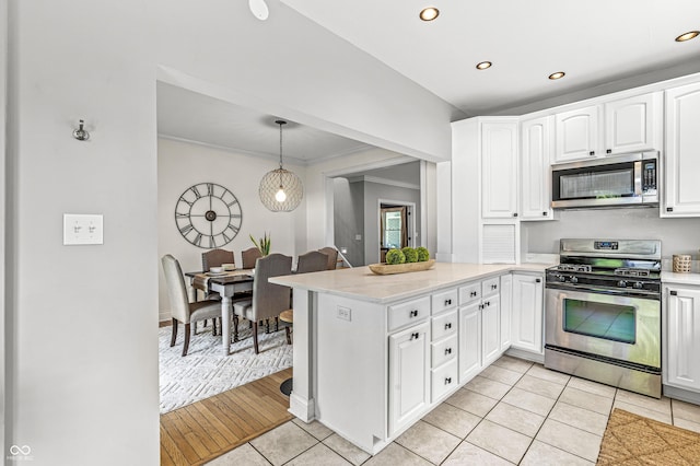 4920 Central Ave, Indianapolis, IN 46205 - kitchen featuring appliances with stainless steel finishes, a peninsula, recessed lighting, white cabinets, and light tile patterned floors