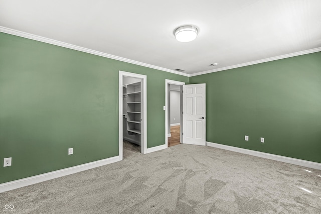 4920 Central Ave, Indianapolis, IN 46205 - unfurnished bedroom featuring ornamental molding, a walk in closet, carpet floors, and a closet