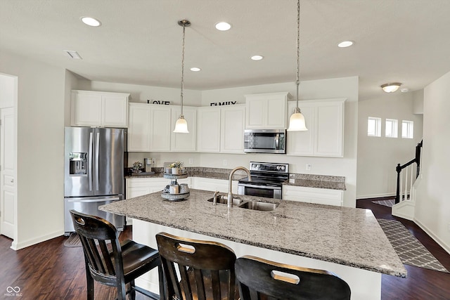 13525 Forest Glade Dr, Fishers, IN 46037 - kitchen with stainless steel appliances, recessed lighting, dark wood-style floors, a breakfast bar area, and a center island with sink