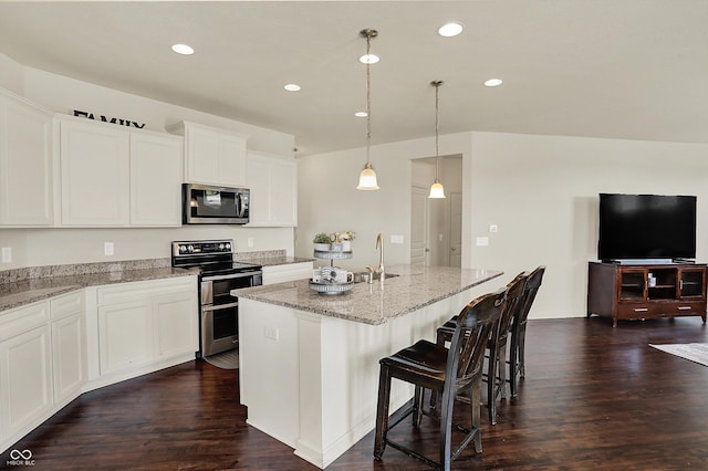 13525 Forest Glade Dr, Fishers, IN 46037 - kitchen featuring stainless steel appliances, an island with sink, recessed lighting, light stone counters, and dark wood-style flooring