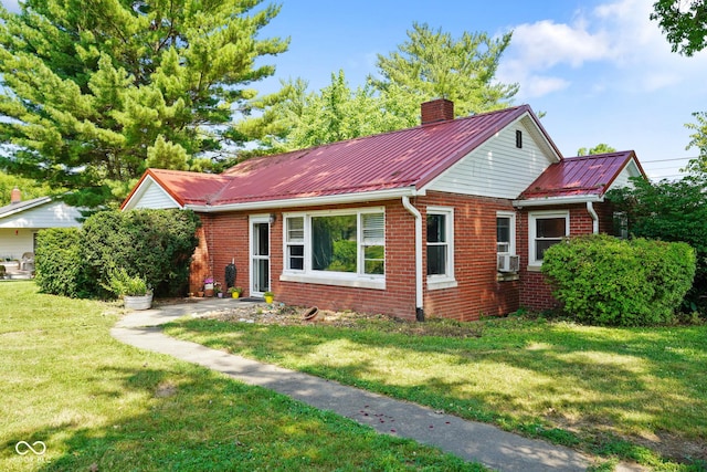 4 Kentwood Dr, Greencastle, IN 46135 - view of front of home with a chimney, a metal roof, a front yard, brick siding, and cooling unit