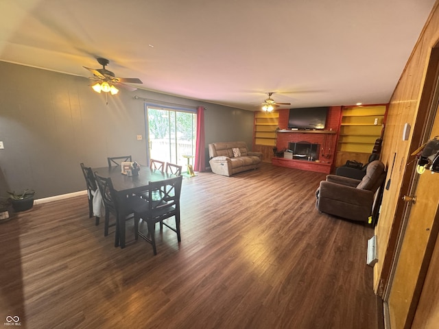 8394 E Mulberry St, Columbus, IN 47203 - dining room featuring a ceiling fan, a fireplace, and dark wood finished floors