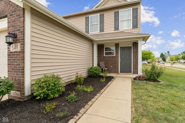 546 Greenwood Trace Dr, Whiteland, IN 46184 - doorway to property featuring brick siding, a yard, and a garage