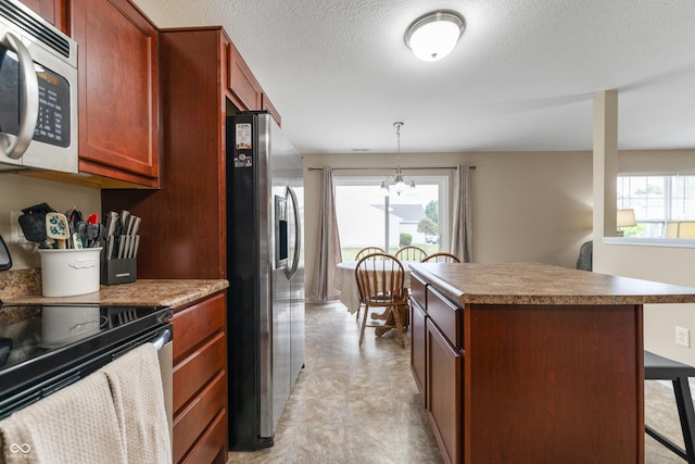 546 Greenwood Trace Dr, Whiteland, IN 46184 - kitchen featuring appliances with stainless steel finishes, plenty of natural light, a kitchen bar, a kitchen island, and a textured ceiling