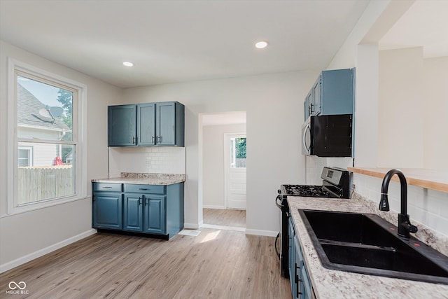 312 E Columbia St, Attica, IN 47918 - kitchen featuring stainless steel gas stove, blue cabinets, light wood-style floors, tasteful backsplash, and recessed lighting